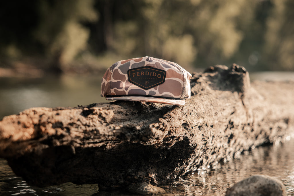 Camoflauge unstructured nylon five panel snapback with black and brown leather perdido patch